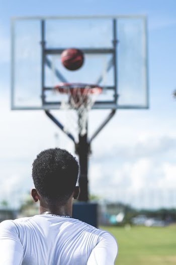man shoot the ball on basketball ring