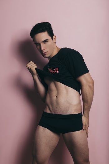 Man Showing His Abdomen While Standing in Front of Pink Wall
