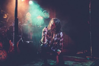 man singing near band