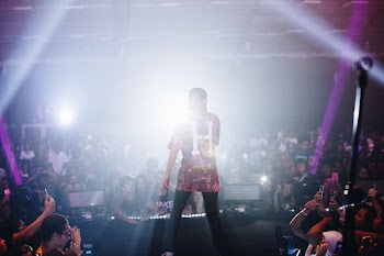 man singing on stage in front of crowd