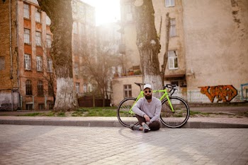 Man Sits on Pavement Near Green Rigid Bike