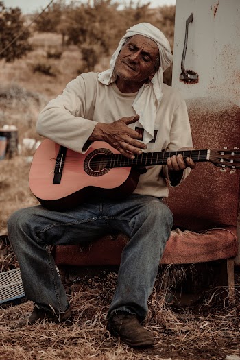 Man Sitting and Playing Guitar