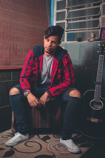 Man Sitting Beside Black Cutaway Acoustic Guitar