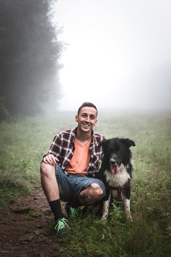 man sitting beside black dog