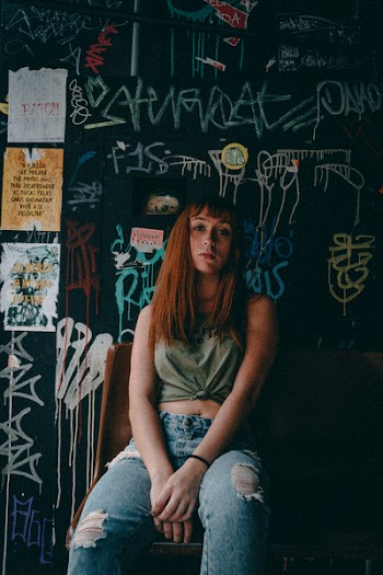 Man Sitting Beside Black Wall