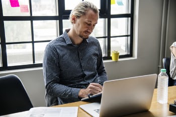 Man Sitting Beside Clear Glass Window