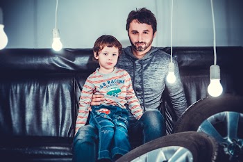 Man Sitting Beside Girl on Sofa Chair