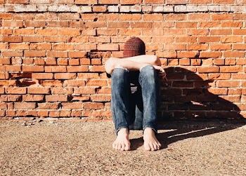 Man Sitting Beside Orange Wall