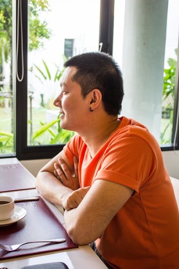 Man Sitting Beside Table Near Clear Glass Window