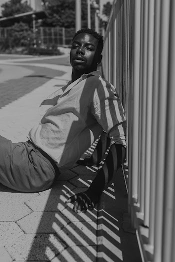 Man Sitting Beside Wall