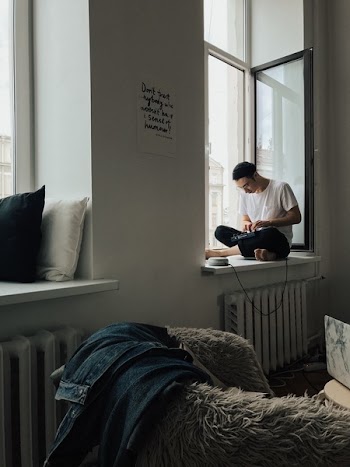 Man Sitting Beside Windowpane