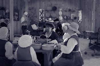 Man Sitting Between Female Near Table