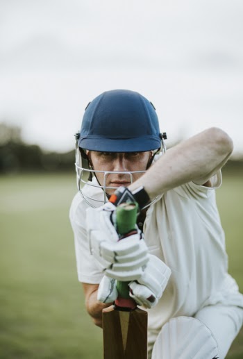 Man Sitting Holding Cricket Bat in Focus Photography
