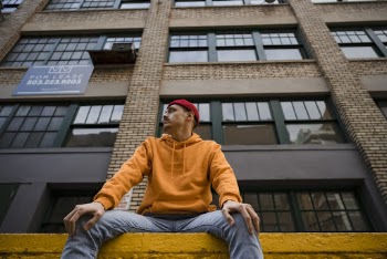 Man Sitting in Front of Brown High-rise Building
