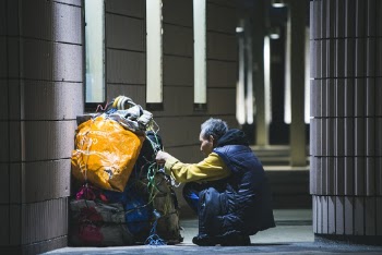 Man Sitting in Front of Bundled Bags