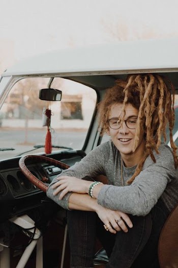 man sitting inside car resting his hand on wheel during daytime