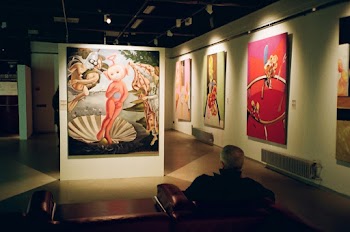 Man Sitting Inside Room Watching Assorted Paintings