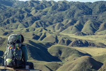 man sitting looking at mountains