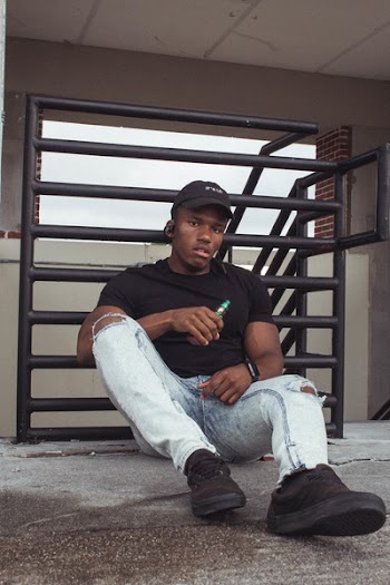 Man Sitting Near Black Railings
