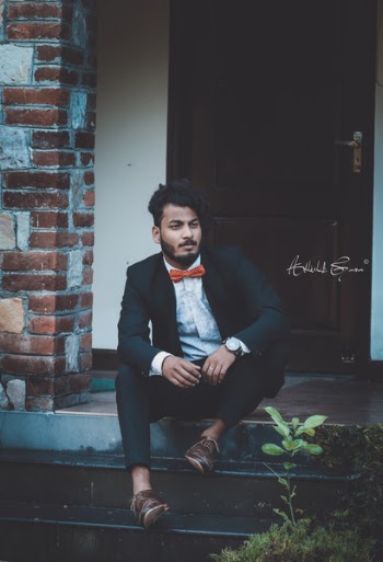 Man Sitting Near Brown Door