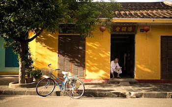 man sitting near door way reading paper