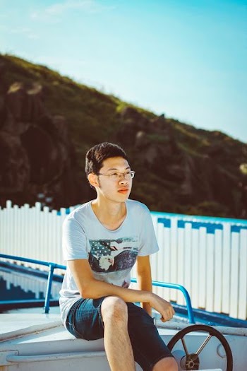 man sitting near white wooden fence during daytime