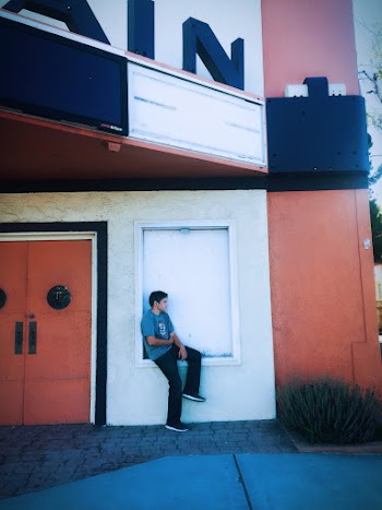 Man Sitting On A Closed Window Of A Building