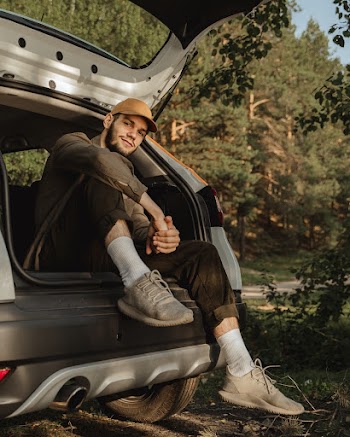 Man Sitting On A Hatchback Vehicle