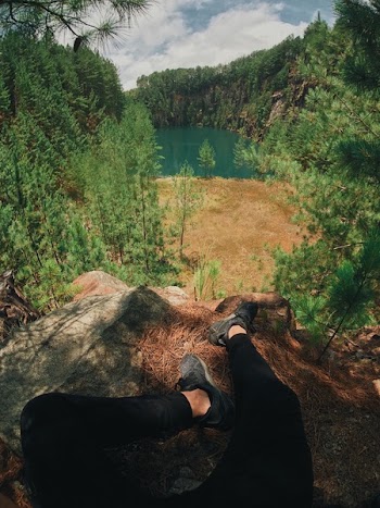 Man Sitting on a Rock Near a Lake