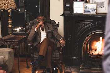 Man Sitting on Armchair While Holding His Drink