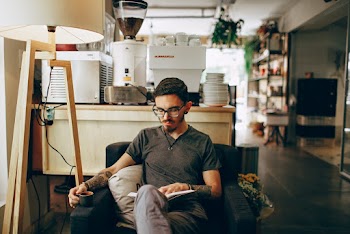 Man Sitting On Armchair White Reading Book