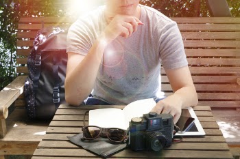 Man Sitting on Bench Leaning on Table