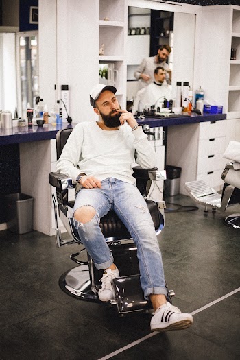 Man Sitting on Black Leather Barber Chair