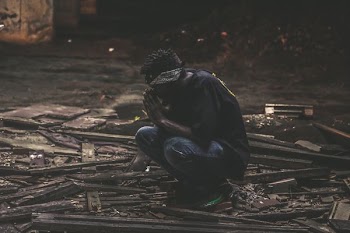 man sitting on black wood planks