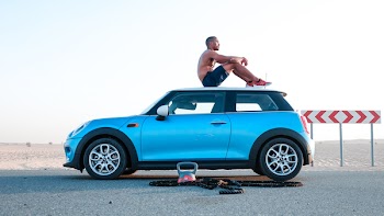 Man Sitting On Blue Mini Cooper