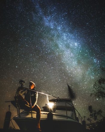 man sitting on boat terrace under blue skt