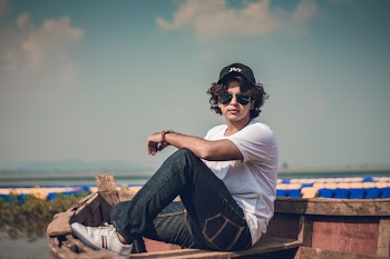 Man Sitting on Boat With One Knee Up