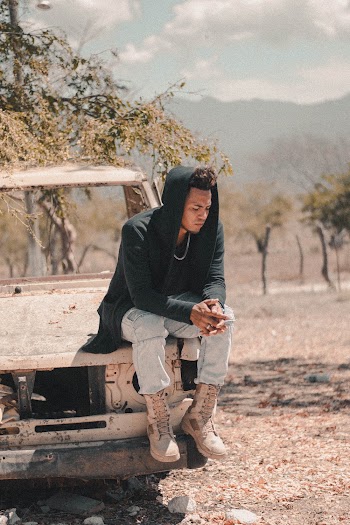 Man Sitting On Broken Vehicle