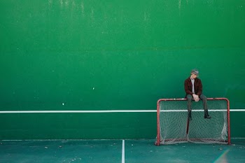 man sitting on brown and white goalie net