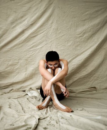 man sitting on brown textile showing body paint