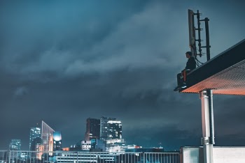 Man Sitting on Building Atop