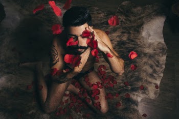 Man Sitting On Carpet Covered With Petals