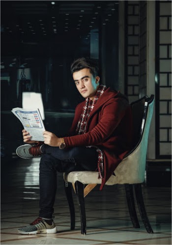 Man Sitting on Chair Holding Booklet