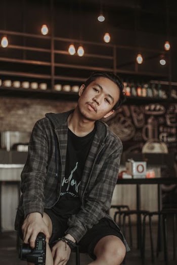 man sitting on chair holding DSLR camera