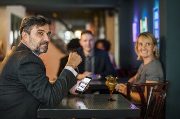 Man Sitting on Chair Holding Smartphone