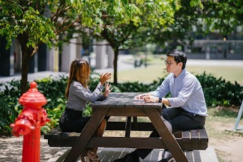 Man Sitting on Chair In Front of Woman