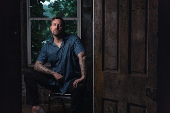 Man Sitting on Chair Near Clear Glass Window