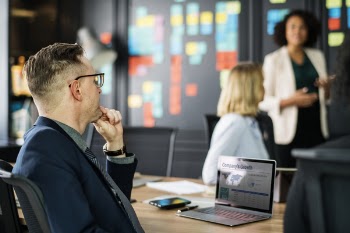 Man Sitting on Chair Near Desk in Meeting Room