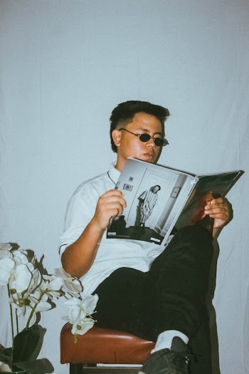 Man Sitting on Chair Reading Book