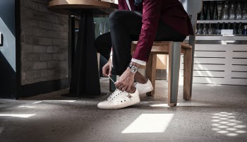 Man Sitting on Chair While Holding Shoe Lace